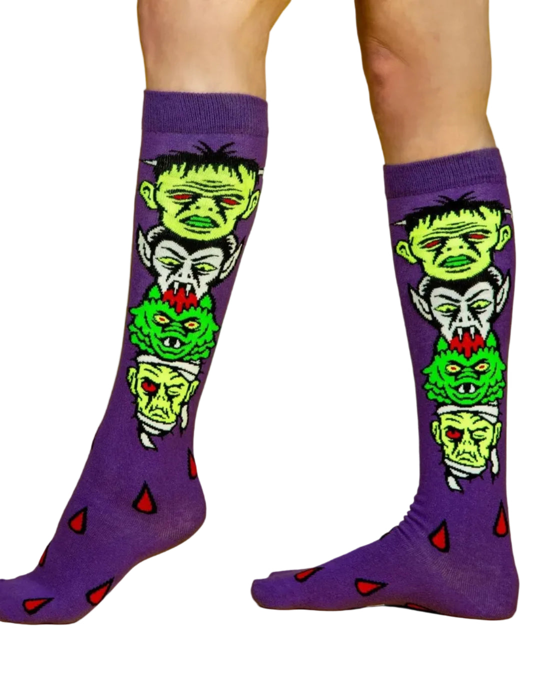 Meias Monster Mash - Lifestyle pelo joelho da Gumball Poodle em roxo, com ilustrações de Frankenstein, Drácula, Múmia e outros monstros clássicos.