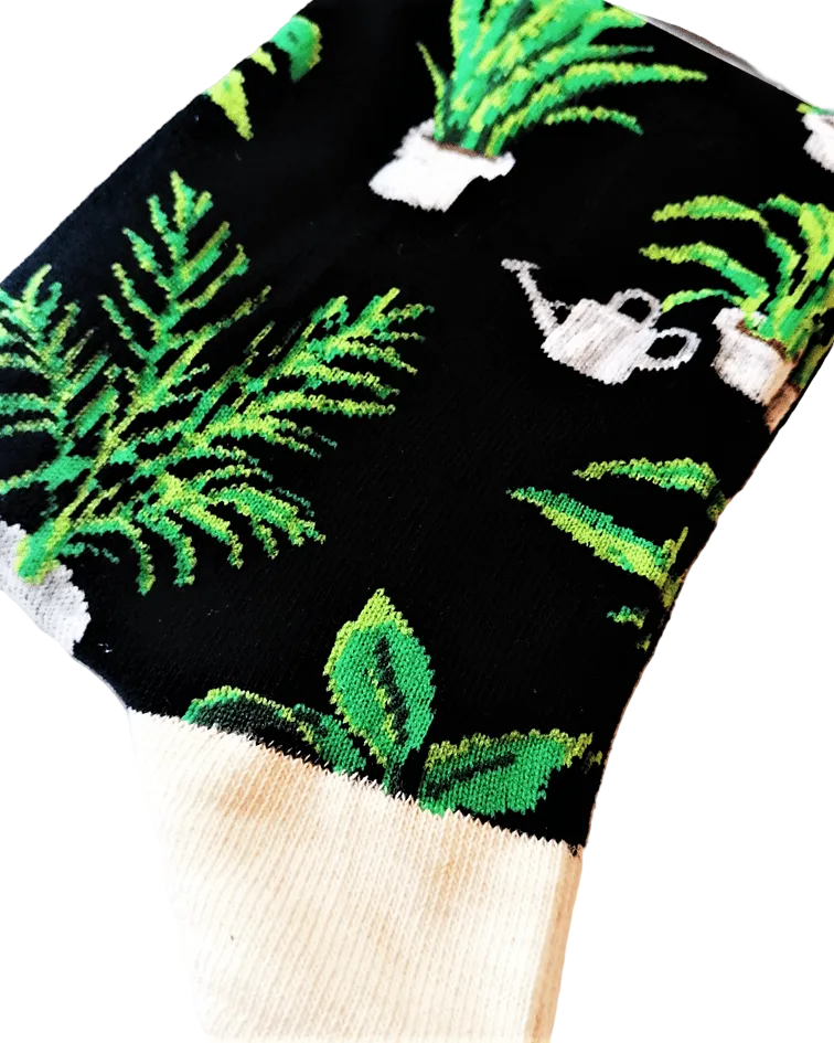 Meias Home Grown - Lifestyle da Socksmith em preto, com padrão de plantas em vasos e pequenos regadores. Detalhe